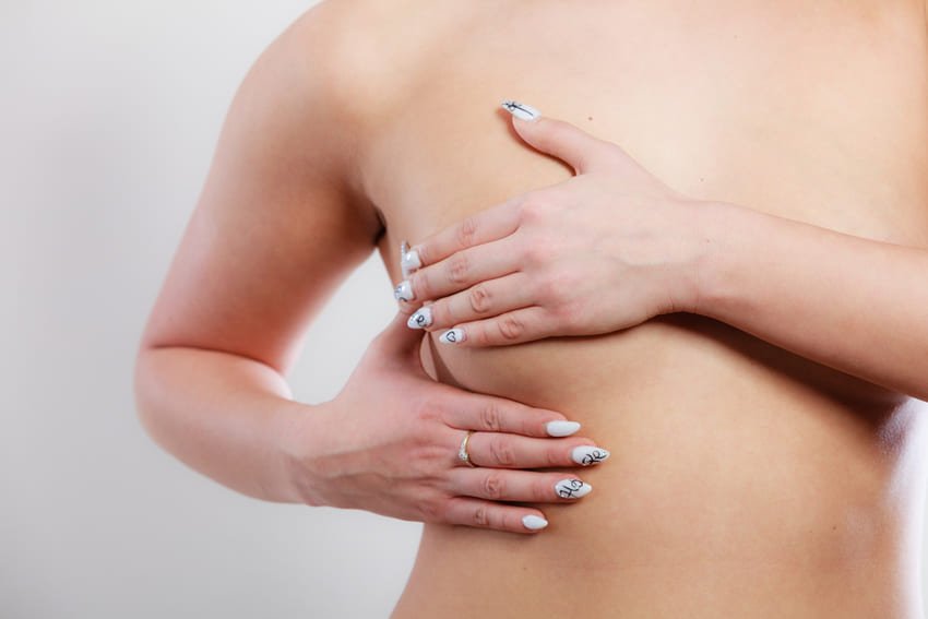 Une femme qui cache son sein